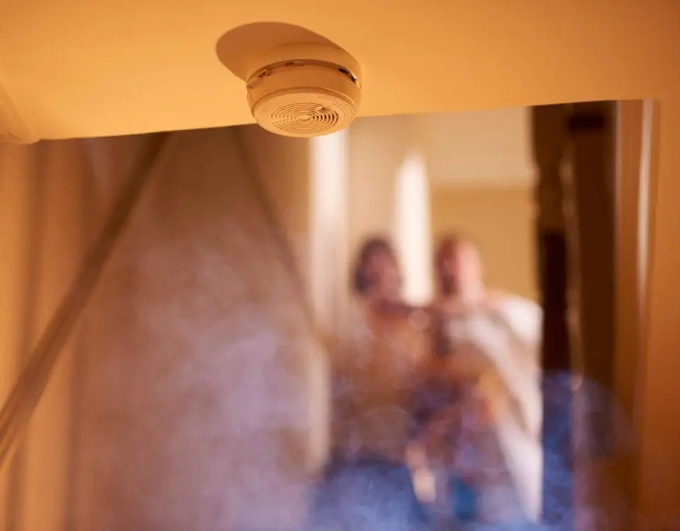 Smoke alarm with blurred background figures