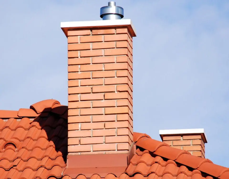 Brick chimney on red tiled roof